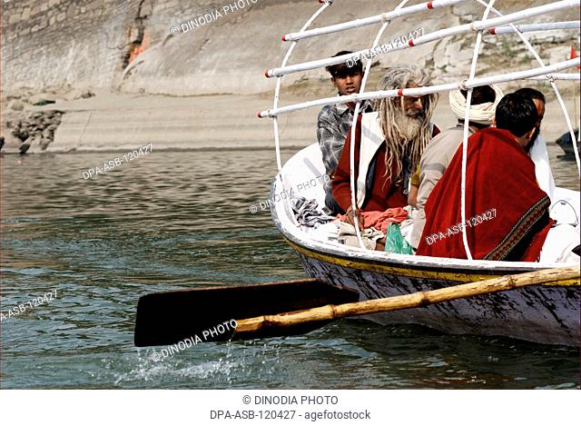 Devotees sit in boat arriving at confluence of Ganges; Yamuna and mythical Saraswati rivers during Ardh Kumbh Mela ; Allahabad ; Uttar Pradesh ; India