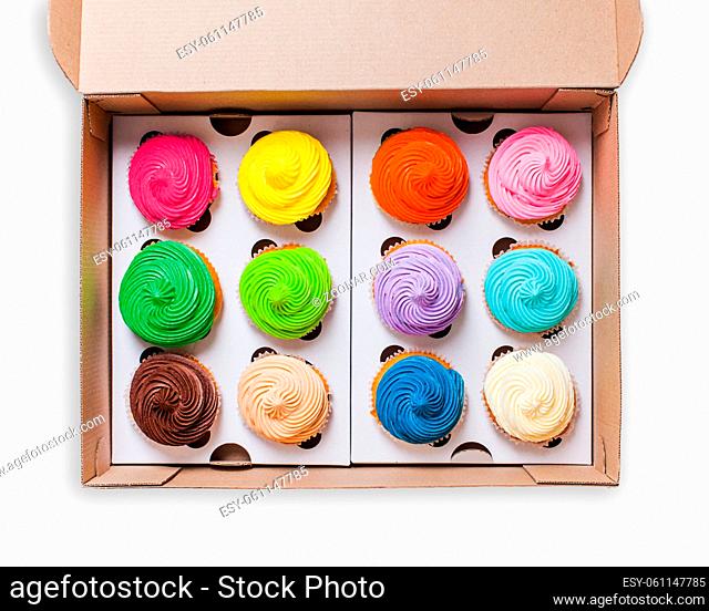 Top view of colourfull rainbow cupcakes in the paper box isolated on white background