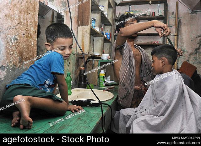 Dhaka, Bangladesh. 2nd May 2022. Children getting a haircut at a barber shop at the Bihari Camp for Eid al-Fitr. Also known as the Geneva camp