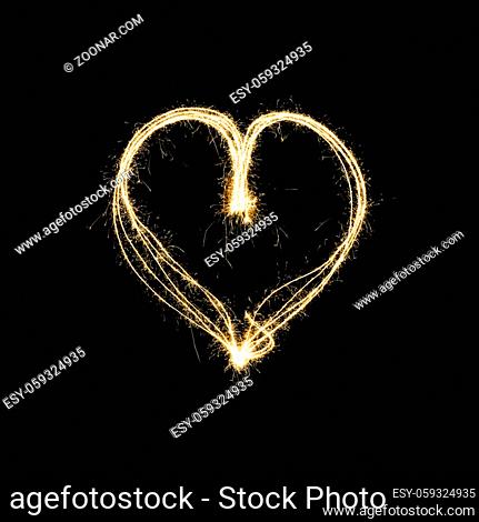 heart shape light painting with sparklers isolated on black background - symbol for love and romance