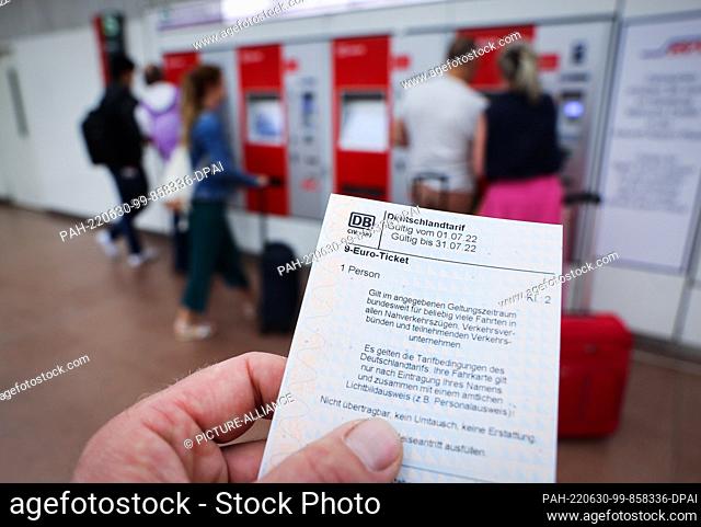 30 June 2022, Hamburg: ILLUSTRATION - A 9-euro ticket for the month of July is seen in front of a row of ticket vending machines of the S-Bahn Hamburg at the...