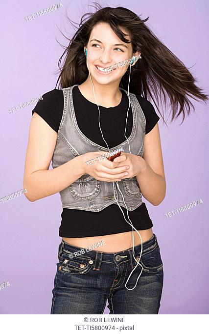 Portrait of teenage girl 16-17 listening to mp3 player