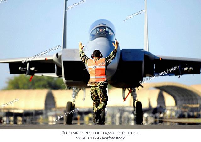 A weapons loader marshals an F-15 Eagle into position Jan  9 at Hickam Air Force Base, Hawaii  The F-15s, from the 199th Fighter Squadron of the Hawaii Air...