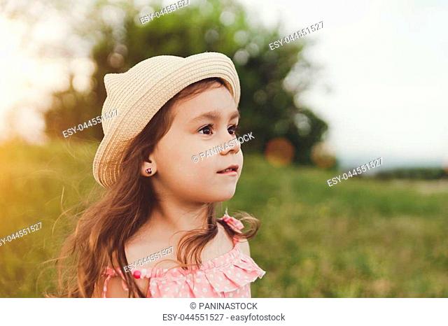 Beautiful little girl in straw hat with long hair looking away in summer  field on sunset, Stock Photo, Picture And Low Budget Royalty Free Image.  Pic. ESY-047575117 | agefotostock