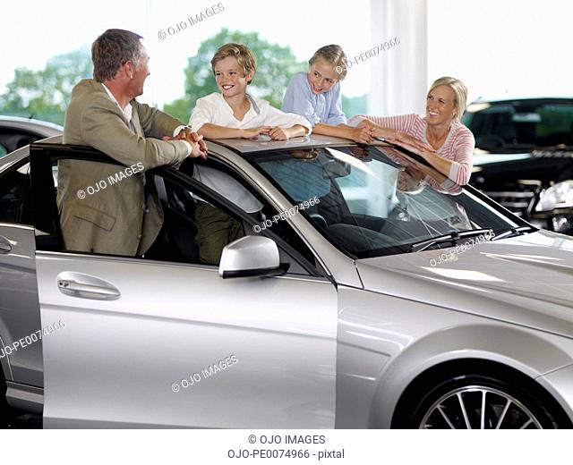 Family looking at new car in showroom