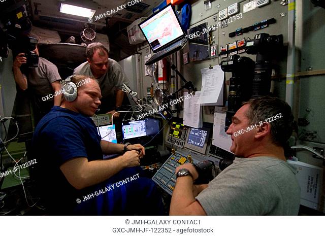 Russian cosmonaut Oleg Kotov (left foreground), Expedition 23 commander, is pictured at the manual TORU docking system controls in the Zvezda Service Module of...