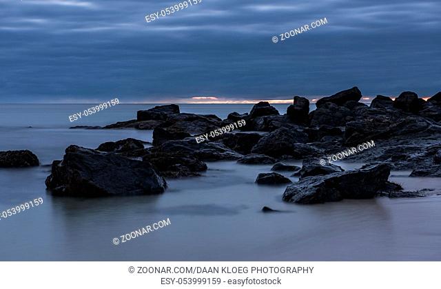 Cornish coast at night with rocks and clouds in the sky, beach at Saint Ives, Cornwall, England