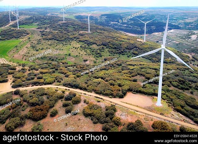 Aerial view of windmills farm for clean energy production on beautiful cloudy sky. Wind power turbines generating clean renewable energy for sustainable...