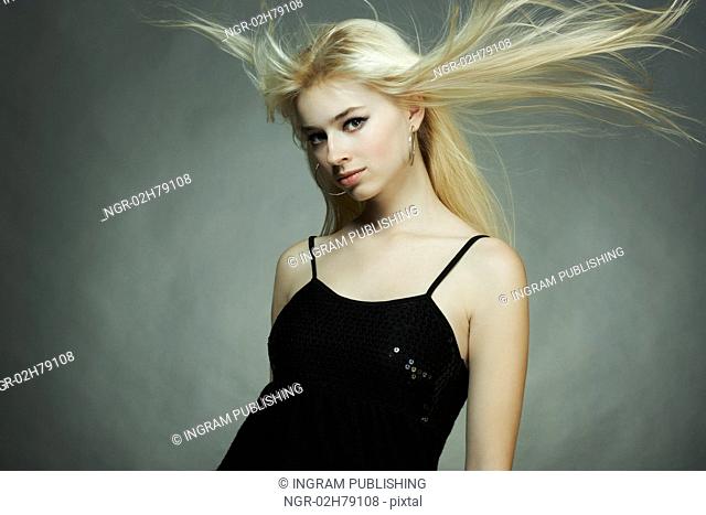Fashion portrait of the young blonde woman with flying hair
