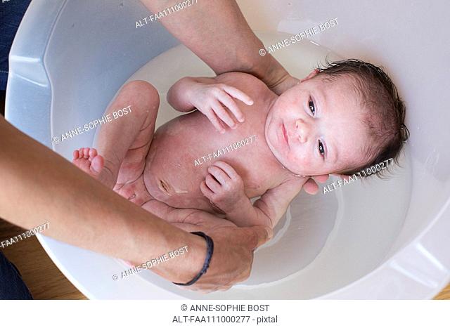New born baby taking bath