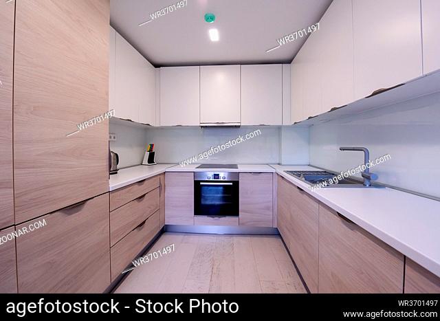 Beautiful modern bright clean kitchen interior in new luxury home with wooden cupboards