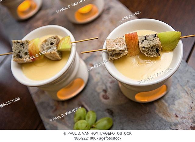 parmesan fondue with bread cubes and apple slices