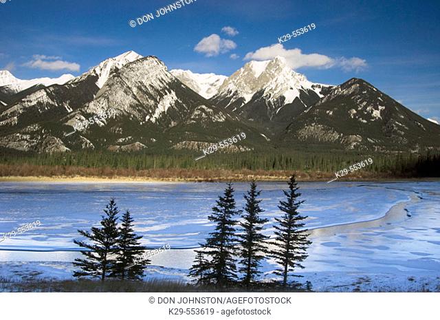 DeSmet Range reflected in open ice and water channel of Jasper Lake. Jasper National Park, Alberta, Canada