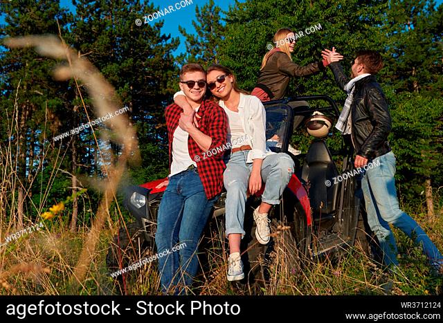 portrait of group young happy people enjoying beautiful sunny day while driving a off road buggy car on mountain nature