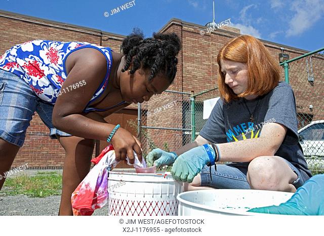 Detroit, Michigan - High school students help children make tie-dye t-shirts  The students are volunteers working in the Summer in the City program