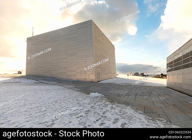Building at the roof of the Oslo Opera House in Bjorvika. Winter, snow, blue sky, white clouds, backlit