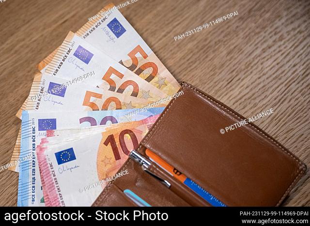 ILLUSTRATION - 24 November 2023, Berlin: Numerous euro banknotes and a wallet are lying on a table. Photo: Hannes P. Albert/dpa