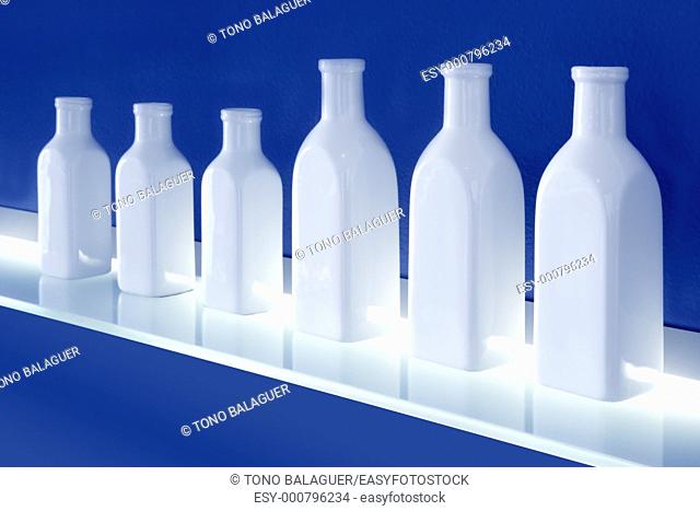 white bottles in row blue background glowing shelf decoration