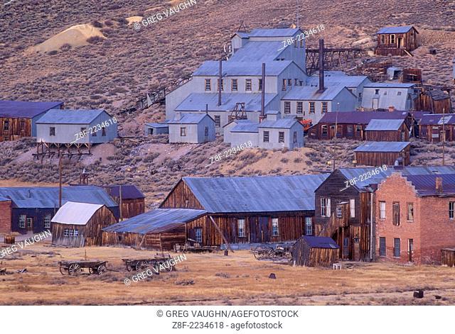 Bodie ghost town at dusk with old Standard Stamp Mill buildings on hillside; Bodie State Historical Park, California