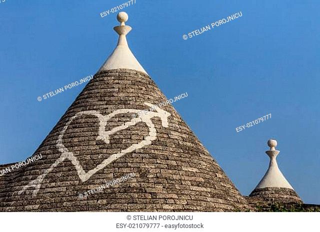 Trulli houses with painted symbols on the conical roofs in Alberobello, Italy