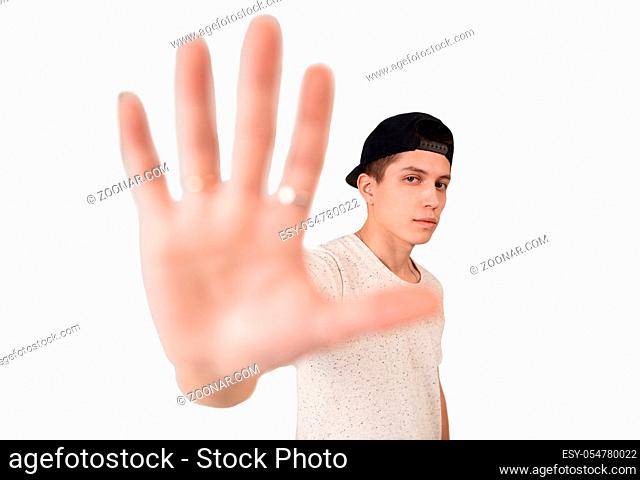 Young handsome rap dancer in black baseball cap showing his palm with rings to the viewr studio close up shot