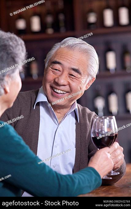 Senior Couple Toasting and Enjoying Themselves Drinking Wine, Focus on Male