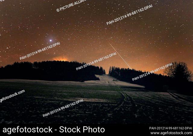 13 December 2020, Bavaria, Stötten: A shooting star burns up in the night sky above the Auerberg. Up to 150 meteorites can be seen every hour in the Geminids'...