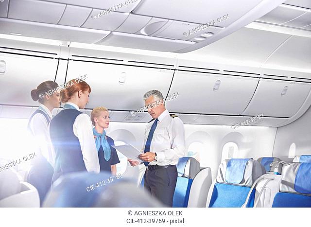 Pilot and flight attendants talking, preparing on airplane