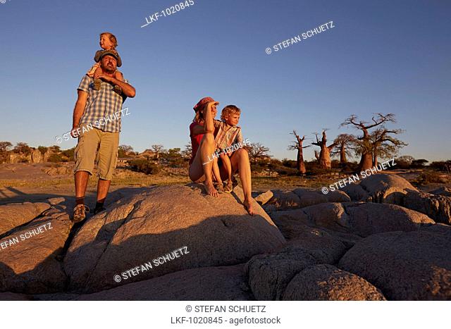 Family looking at view at sunset, Kubu Island, Makgadikgadi Pans National Park, Botswana