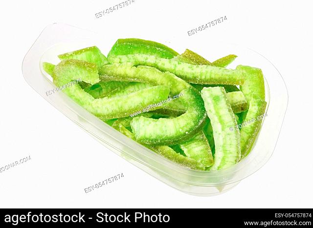 Daily food product - candied sweet green grapefruit with sugar  in a transparent plastic container. Isolated with patch on white studio macro