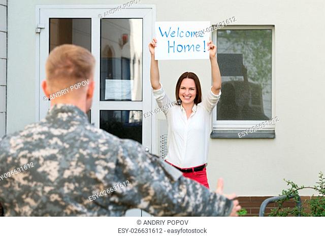 Happy Female Welcoming Her Husband Home From Army Leave