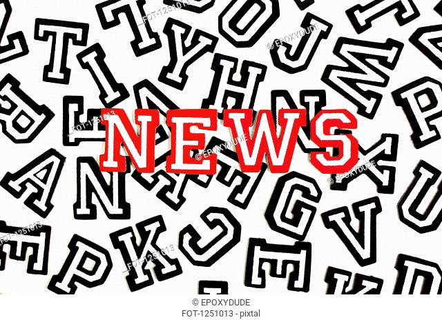 Red outlined varsity font stickers spelling News on top of black outlined letters