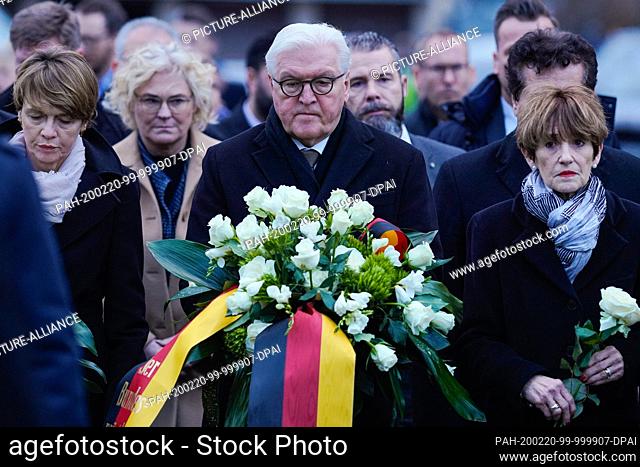 20 February 2020, Hessen, Hanau: Frank-Walter Steinmeier (M), Federal President, holds a bouquet of flowers during a commemoration ceremony and stands next to...