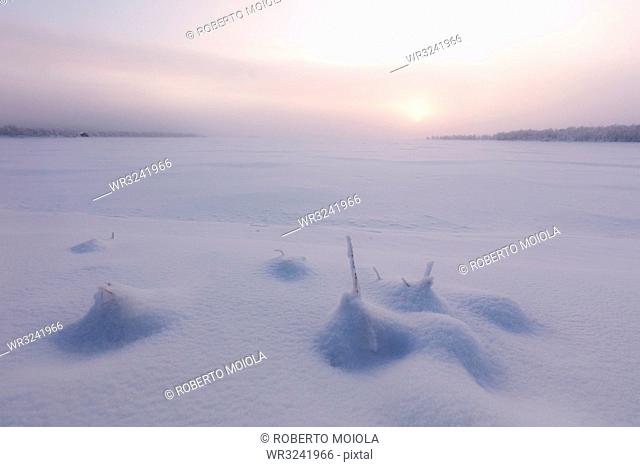 Misty sunrise on the snowy landscape, Muonio, Lapland, Finland, Europe