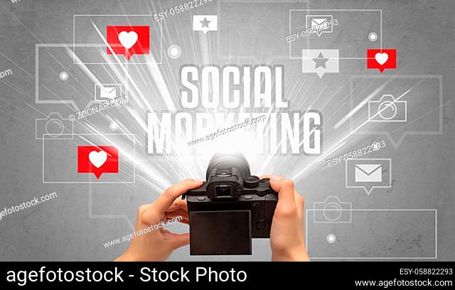 Close-up of a hand taking photos with SOCIAL MARKETING inscription, social media concept