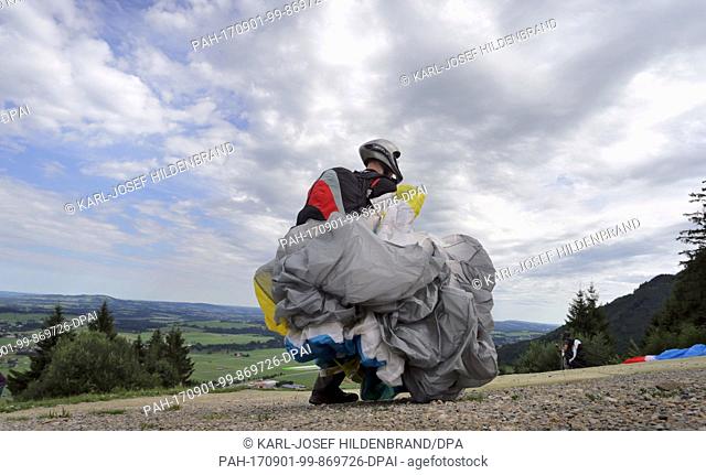 Pupils of a paragliding school prepare for their examination flight on Buchenberg mountain near Buching, Germany, 30 July 2017