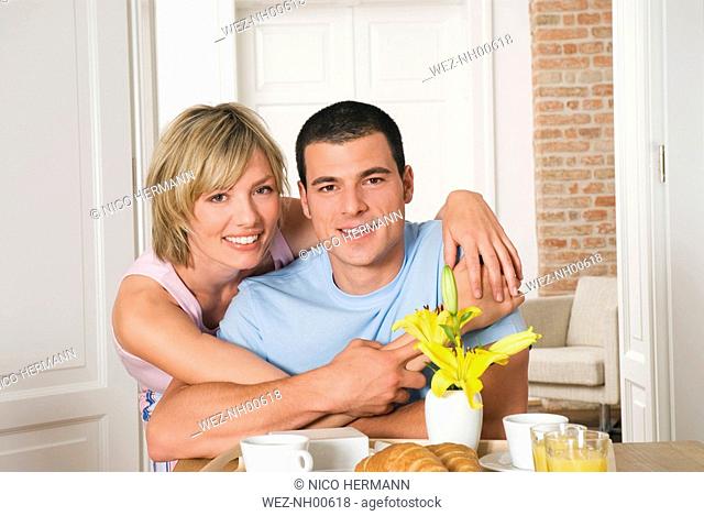 Young couple hugging at breakfast table, close-up