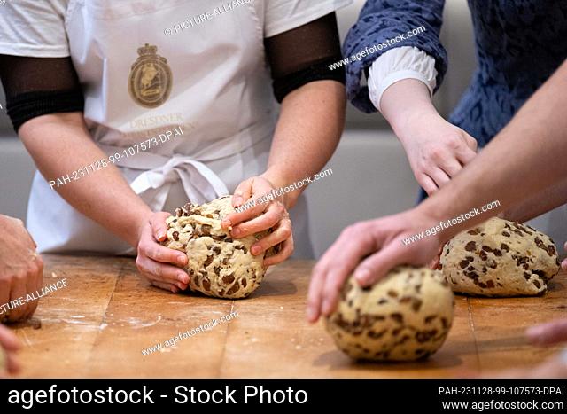 28 November 2023, Saxony, Dresden: Artists from the Theater Junge Generation (tjg) and dancers from the Palucca University bake stollen together in the Dresden...