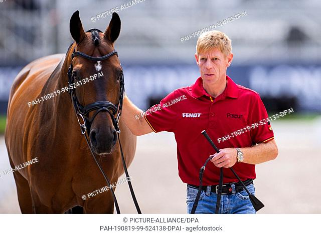19 August 2019, Netherlands, Rotterdam: European championship, equestrian sport, jumping, vet check: Marcus Ehning from Germany presents his horse Comme il Faut...