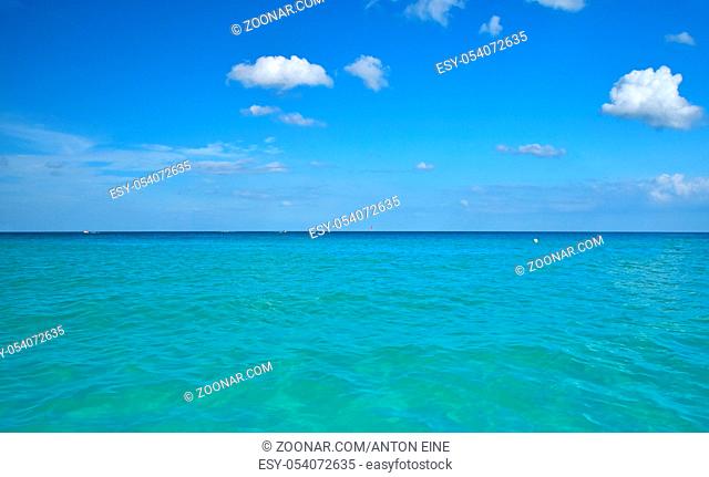 Tranquil seascape of turquoise blue sea water and clear sky with horizon, summer day, low angle view
