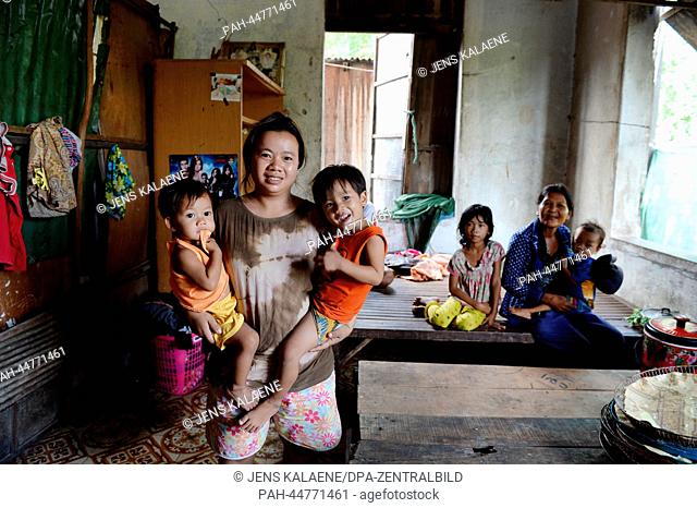 Simal (24) stands with her children Sophearvth (1) and Pisith (3) in their house in the Chhba Anmpov Slum on the grounds of a graveyard in Phnom Penh, Cambodia
