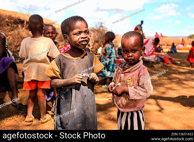 Unknown Masai village near Amboselli park, Kenya - April 02, 2015: Poor dirty Masai children with faces and mouth covered with flies