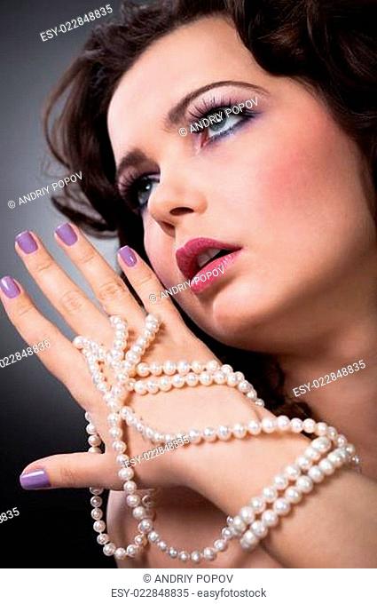 Beautiful Young Woman Holding Pearl Necklace