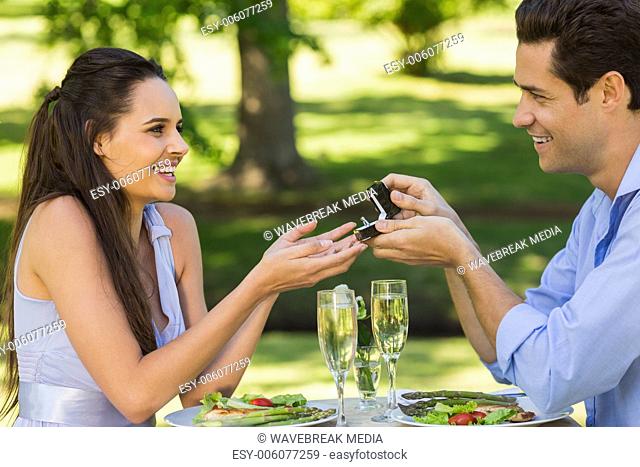 Man propose woman while they have romantic date at an outdoor caf?®