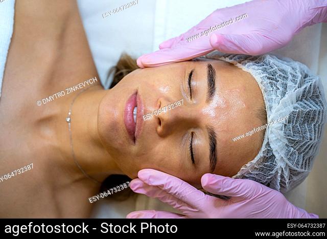 Face massage after skin care procedure in a beauty spa salon, cosmetologist, aesthetic clinic