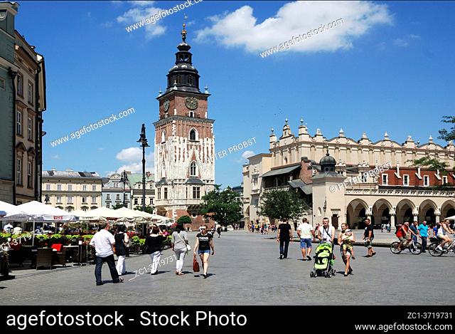 Tourists on the Main Square of Krakow in Poland with Town Hall Tower and Cloth Halls - Poland
