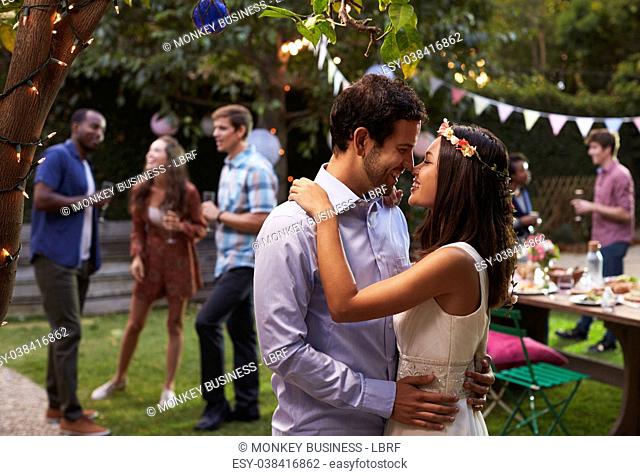 Young Couple Celebrating Wedding With Party In Backyard