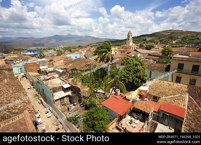 Panoramic view over the pantiled rooftops of Trinidad towards the belltower of the Convento de San Francisco de asis and the mountains of the Sierra del...