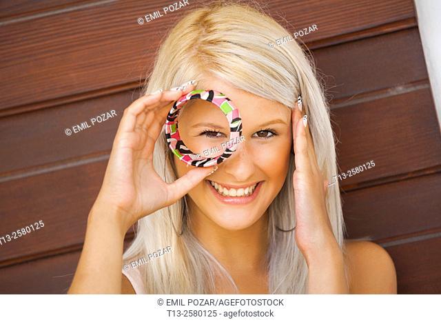 Young lady peeking through bracelet ring