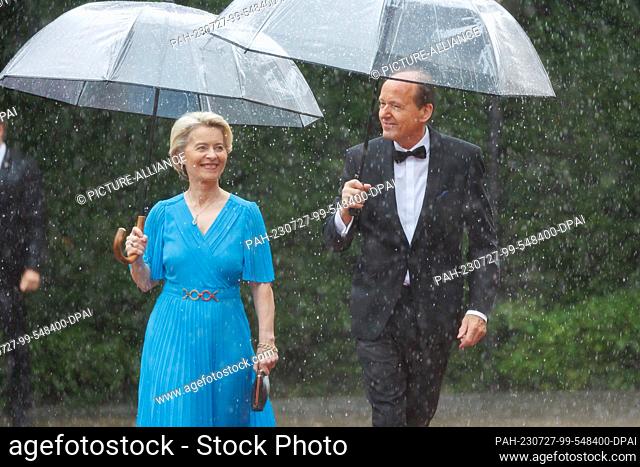 25 July 2023, Bavaria, Bayreuth: Ursula von der Leyen (CDU), President of the EU Commission, and husband Heiko arrive in the rain for the opening of the Richard...